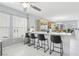 Modern kitchen design features white cabinets, tiled floors, a breakfast bar and lots of natural light at 3966 Crystal Trip Ct, Las Vegas, NV 89129