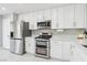 A kitchen with stainless steel appliances, white cabinets, tile flooring, and bright overhead lighting at 3966 Crystal Trip Ct, Las Vegas, NV 89129