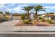 Charming single-story home featuring a two-car garage, mature palm trees, and desert landscaping at 4016 Stormcrest Dr, Las Vegas, NV 89107