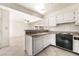 Functional kitchen with white cabinets, a black oven, and an open view to the living area at 4016 Stormcrest Dr, Las Vegas, NV 89107