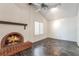 Bright living room with dark wood floors, brick fireplace, ceiling fan, and natural light at 4016 Stormcrest Dr, Las Vegas, NV 89107