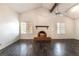 Spacious living room boasts vaulted ceiling, dark wood floors, a fireplace, and natural light at 4016 Stormcrest Dr, Las Vegas, NV 89107