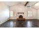 Spacious living room boasts vaulted ceiling, dark wood floors, a fireplace, and natural light at 4016 Stormcrest Dr, Las Vegas, NV 89107