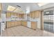 Bright kitchen with tiled floors, beige cabinets, white appliances and sliding glass door at 4386 El Cebra Way, Las Vegas, NV 89121