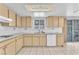 Well-lit kitchen featuring beige cabinets, white appliances and sliding glass door at 4386 El Cebra Way, Las Vegas, NV 89121
