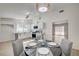 Bright dining area featuring a modern light fixture, table set for four, and an updated kitchen in the background at 4496 Skyview Dr, Las Vegas, NV 89104