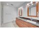 Bathroom with double sink vanity, black countertop and wood cabinets under flattering lighting at 4525 Dean Martin Dr # 909, Las Vegas, NV 89103