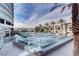 Contemporary outdoor pool area with clear glass surround, palm trees and lounge chairs at 4525 Dean Martin Dr # 909, Las Vegas, NV 89103