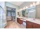 Bathroom featuring double sinks, tile flooring, and a glass-enclosed shower with an attached bedroom view at 489 Open Hill Ave, Henderson, NV 89011