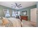 Comfortable bedroom featuring a ceiling fan, dresser, and large window with decorative curtains at 489 Open Hill Ave, Henderson, NV 89011