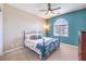 Cozy bedroom featuring carpet, blue accent wall, ceiling fan, and natural light from the arched window at 489 Open Hill Ave, Henderson, NV 89011