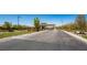 Community entrance features a brick-paved road, signage, and a gatehouse, all surrounded by mature trees at 489 Open Hill Ave, Henderson, NV 89011