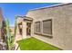 Exterior showcasing desert landscaping and two windows on a stucco home with a patio and clear blue sky at 489 Open Hill Ave, Henderson, NV 89011