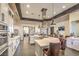 Modern kitchen boasts stainless hood, white cabinets, large center island with breakfast bar, and lots of space for entertaining at 489 Open Hill Ave, Henderson, NV 89011