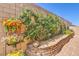 Beautiful landscaping featuring colorful flowers, lush greenery, and a decorative brick retaining wall at 489 Open Hill Ave, Henderson, NV 89011