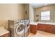 Well-equipped laundry room featuring modern washer and dryer, plus ample countertop space and storage at 489 Open Hill Ave, Henderson, NV 89011