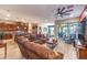 Open-concept living room featuring a large sectional, ceiling fan, and sliding glass doors to the outdoor patio at 489 Open Hill Ave, Henderson, NV 89011
