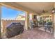 Inviting covered patio with stone fireplace, ceiling fan and comfortable seating area at 489 Open Hill Ave, Henderson, NV 89011