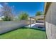 Backyard featuring a covered patio, artificial turf, and block wall fencing at 5116 Blue Onion Cir, North Las Vegas, NV 89031