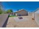 Backyard featuring a paver patio with fire pit, gravel, artificial turf, and block wall fencing at 5116 Blue Onion Cir, North Las Vegas, NV 89031