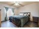Charming bedroom features hardwood floors, a ceiling fan, curtains, and a window with natural light at 5116 Blue Onion Cir, North Las Vegas, NV 89031