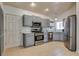 Updated kitchen with stainless steel appliances, grey cabinetry, light countertops and tiled flooring at 5116 Blue Onion Cir, North Las Vegas, NV 89031