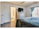Comfortable bedroom with hardwood floors, natural light from the window, and an ensuite bathroom at 5116 Blue Onion Cir, North Las Vegas, NV 89031