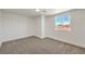 This bedroom features neutral carpet, white walls, and a window with a view at 5200 Blanton Dr, Las Vegas, NV 89122