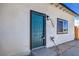Close up of a blue front door and address on a modern single-story home at 5200 Blanton Dr, Las Vegas, NV 89122
