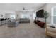 Open-concept living room featuring a sectional sofa, tile floors, and a decorative accent wall at 5234 Savannah Rose St, Las Vegas, NV 89149