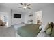 Carpeted main bedroom with a tv, a gray ottoman, and an upholstered bed at 5234 Savannah Rose St, Las Vegas, NV 89149