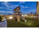 Backyard playground showcasing a wooden play structure with slide, a covered patio, and lush artificial grass at 5234 Savannah Rose St, Las Vegas, NV 89149