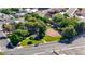 Overhead view of a neighborhood park featuring lush trees, green grass, a playground, and walking paths at 524 Hopi Pl, Boulder City, NV 89005