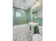 Bathroom featuring green subway tiles, pedestal sink, gold hardware, and decorative floor tiles at 524 Hopi Pl, Boulder City, NV 89005