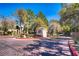 Community entrance gate with brick-paved road and mature trees at 525 Indian Princess Dr # 101, Las Vegas, NV 89145