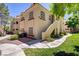 Inviting condo exterior featuring lush landscaping, stucco facade, and private entrance staircase at 525 Indian Princess Dr # 101, Las Vegas, NV 89145