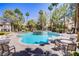 Community pool surrounded by palm trees and lounge chairs, perfect for relaxation at 525 Indian Princess Dr # 101, Las Vegas, NV 89145