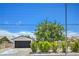 Charming single-story home with well-maintained landscaping, a black two-car garage, and a blue sky at 5279 Consul Ave, Las Vegas, NV 89142