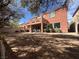Backyard with partially covered patio with second story patio, lush trees and block wall at 530 Calahonda Ct, Las Vegas, NV 89138