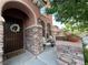 Inviting front porch with stone accents, seating area, potted plants, and a decorative door at 530 Calahonda Ct, Las Vegas, NV 89138