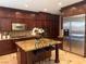 Well-equipped kitchen with custom cabinets, stainless steel appliances, granite countertops, and a center island at 530 Calahonda Ct, Las Vegas, NV 89138