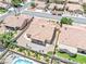 An aerial perspective of the home featuring its tile roof, covered patio, and a community swimming pool at 5704 Owl Butte Ct, Las Vegas, NV 89149