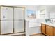 Bright bathroom with a shower over a bathtub with natural light from the window at 5704 Owl Butte Ct, Las Vegas, NV 89149