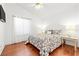 Bright bedroom with hardwood floors, ceiling fan, and a large window for natural light at 5704 Owl Butte Ct, Las Vegas, NV 89149