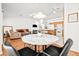 Open-concept living space features a modern round table, cozy seating, and a well-equipped kitchen with white appliances at 5704 Owl Butte Ct, Las Vegas, NV 89149