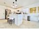 A well-lit kitchen with white cabinets, stainless steel appliances, island, and travertine floors at 5984 Emerald Canyon Dr, Las Vegas, NV 89142