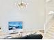 Bright living room with high ceilings, modern chandelier, and a large TV, creating an inviting space at 5984 Emerald Canyon Dr, Las Vegas, NV 89142