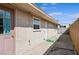 Exterior of home showing backyard with door and window, a concrete walkway, and a partial fence at 600 Federal St, Henderson, NV 89015