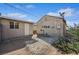 Backyard with gravel landscaping showing tan outbuilding and tan stucco sided home under a blue sky at 600 Federal St, Henderson, NV 89015