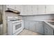 Functional kitchen featuring white cabinets, white appliances, tile backsplash, and tile flooring at 600 Federal St, Henderson, NV 89015
